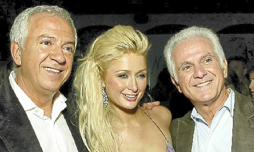 FRIENDS IN HIGH PLACES: Fashion designers Paul Marciano, left, and Maurice Marciano with Paris Hilton. FRIENDS IN HIGH PLACES: Fashion designers Paul Marciano, left, and Maurice Marciano with Paris Hilton.